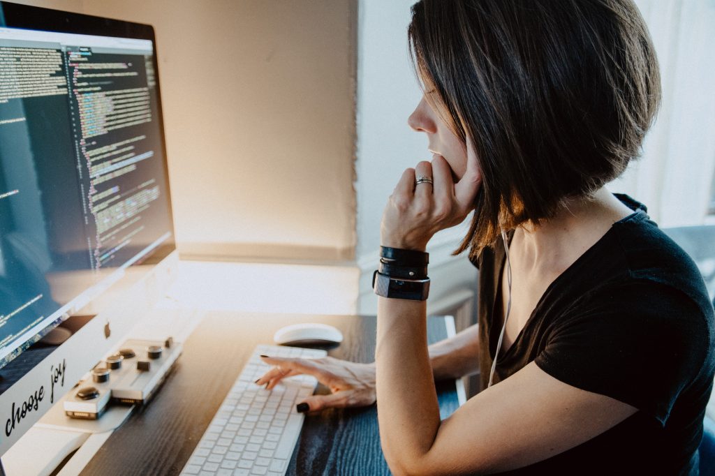 A woman sitting at a table using a laptop computer